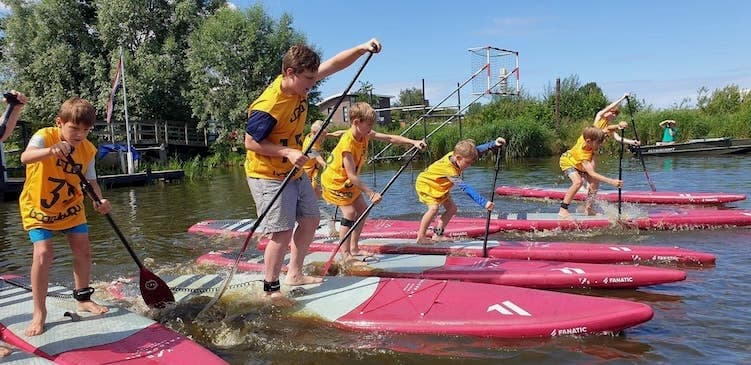Group of athletes paddling in formation on flatwater