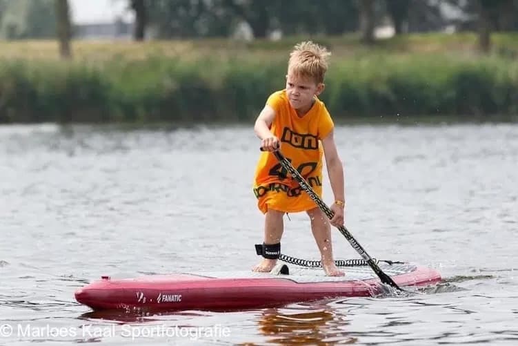 Athlete focused on the water with family on the beach