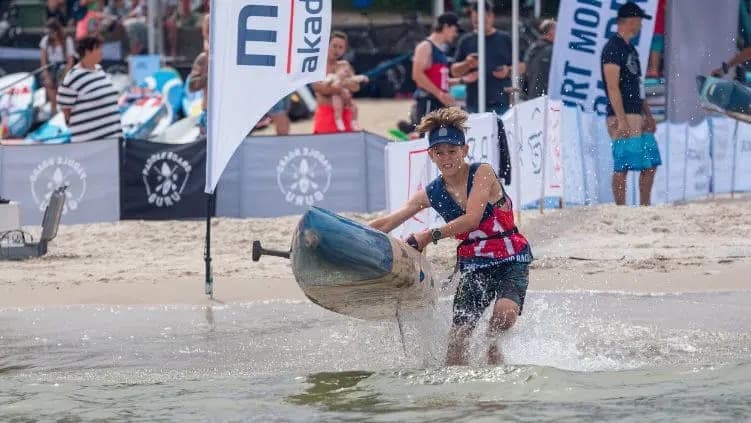 Athlete sprinting on the beach with a paddle