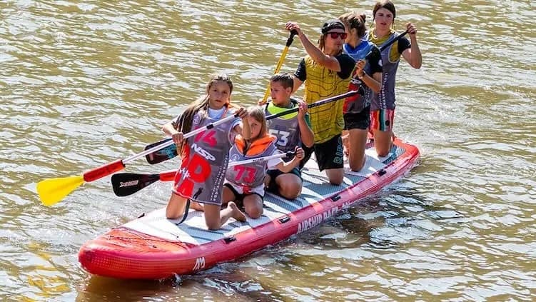 Youth team paddling together on an inflatable race board